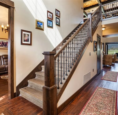 Custom wood flooring and stair rail in a luxury home built by Saddle Horn Custom Homes