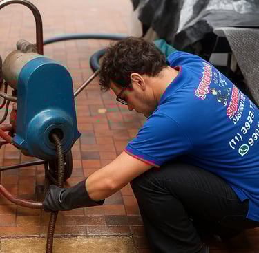 tecnico desentupindo uma caixa de gordura
