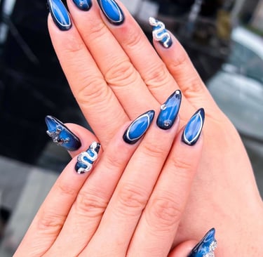 Deep navy and blue ombre fall nails with silver 3D crystal snake accents.