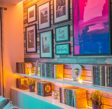 Feature wall with gallery art, bold colors, books, and LED lighting