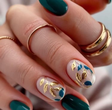 Emerald green fall nails with gold foil leaf accents on short rounded nails.