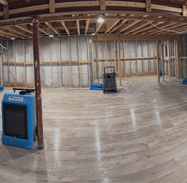 alt="Flooded basement undergoing storm damage restoration with industrial drying equipment"