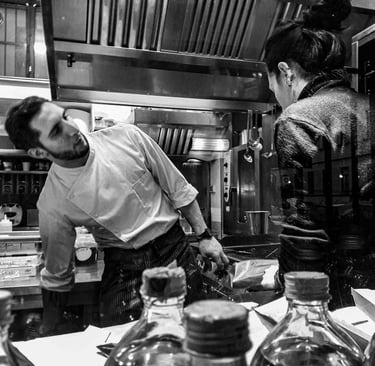 a man and woman in a kitchen with jars of jars