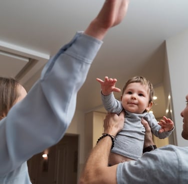 a man and woman holding a baby in a living room