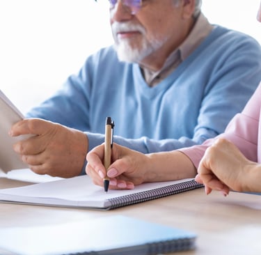 a man and woman sitting at a table with a tablet