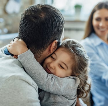 a man and a little girl are sitting on a couch