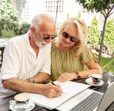a man and woman sitting at a table with a laptop