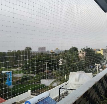 Evening view of a Koramangala balcony with safety netting softly lit by ambient lights.