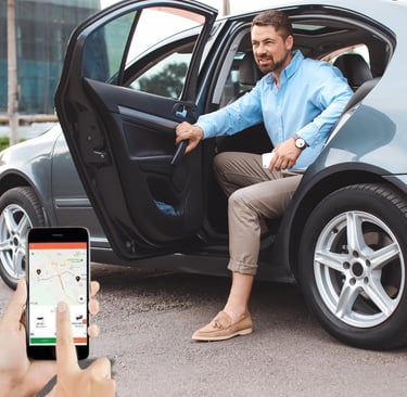 Um homem sentado em um carro com um celular na mão