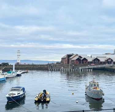 a group of boats in Newhaven harbour at the pier