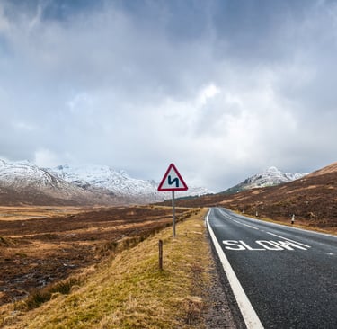a road warning sign on road through a mountain