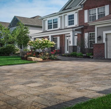 a brick paver driveway with earthy colors and dark border