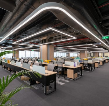 A large open office with a desk and a plant