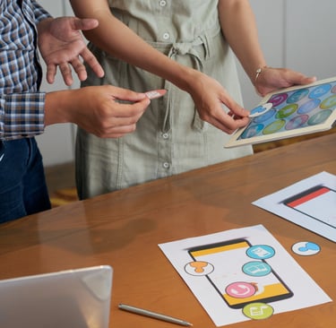 Designers olhando tablet e papeis com imagens