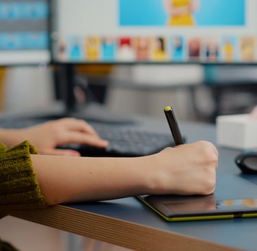 Designer usando tablet em frente a computador