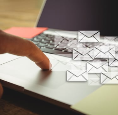 Mão em um notebook com ícones de e-mails