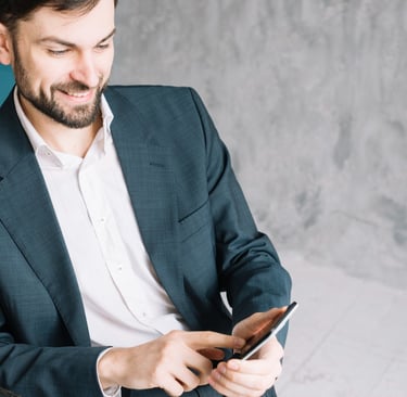 Advogado sorridente, usando terno e olhando o seu celular enquanto utiliza o Instagram