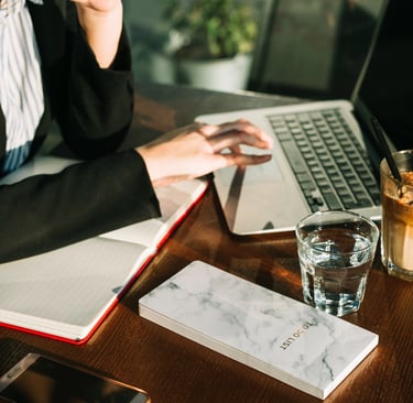 Advogada trabalhando em uma mesa fazendo tarefas de marketing jurídico no notebook