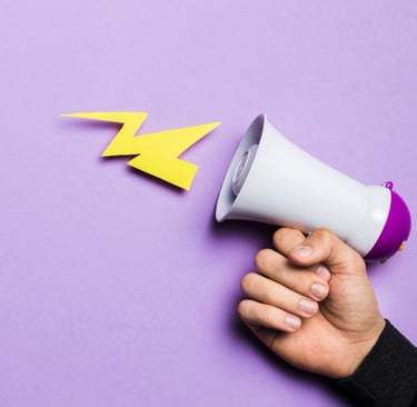 Imagem de mão segurando megafone com fundo roxo