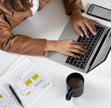 Webmaster programando landing page com notebook na mesa