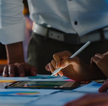 Duas pessoas e mesa com papéis e tablet relacionados a marketing