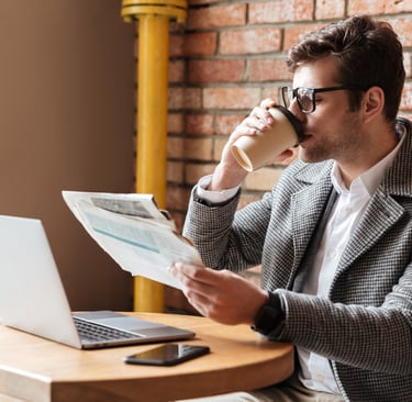 Advogado bebendo café enquanto lê jornal com uma reportagem para a qual concedeu entrevista