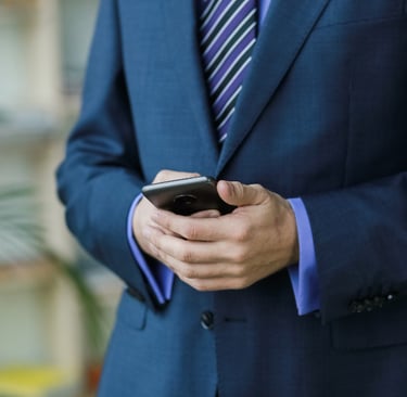 Advogado de terno com o celular na mão