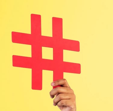 Uma mão segurando uma hashtag com um fundo amarelo