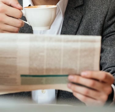 Advogado lendo jornal e tomando café