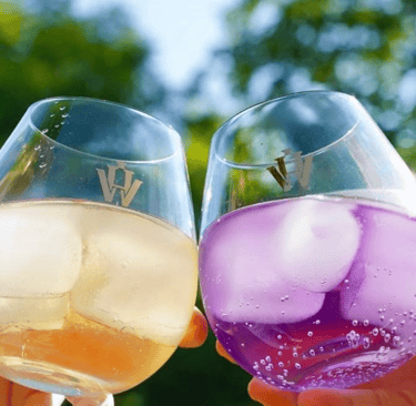 Photo of two glasses against eachother with Holy-Water Cuberdon Gin inside