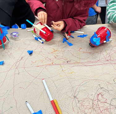 a group of students creating drawing bots at a workshop