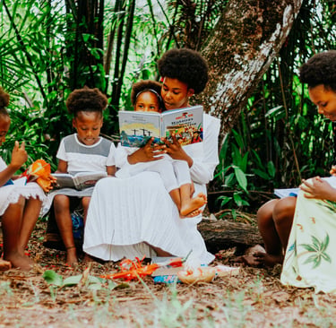 Jeunes femme assise avec les enfants sous un arbres