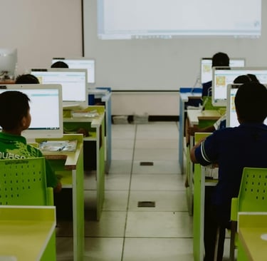 Students using computers in a classroom showing the role of media in education and socialization.