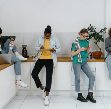 Young adults using digital devices showing the impact of mass media on social interaction.