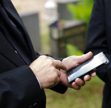 two men in suits and ties are holding their phones - Illford Academy