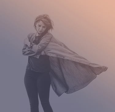 Moody portrait of a person standing with eyes closed, arms crossed, and a long shirt flowing in the