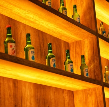 a shelf of bottles of beer and bottles of soju, korean alcohol