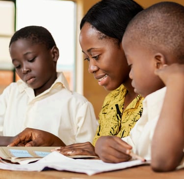 Une enseignante entrain d'expliquer à deux élèves.  Tolanda, suivi scolaire
