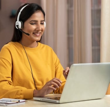 Young woman learning French online with laptop and headset