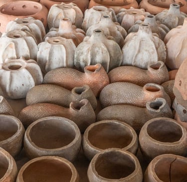Long row of clay products from bird nests to pots of various sizes and shapes