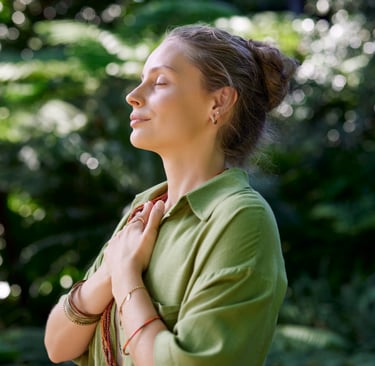 Frau mit geschlossenen Augen und Händen auf dem Herzen – Symbolbild für Selbstliebe, innere Stärke.