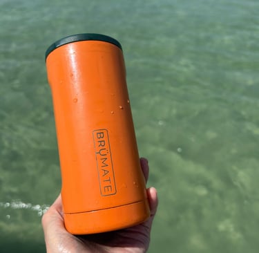 Brandy holding a BrüMate Hopsulator Trio can cooler filled with a drink on a sunny day.