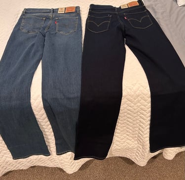 Two pairs of Levi’s 315 Shaping Bootcut jeans laid side by side on a bed — medium wash and dark wash