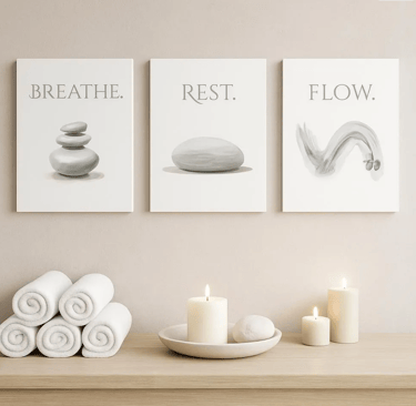 Zen wall art with spa decor featuring white towels, candles, and framed posters with serene stones and text.