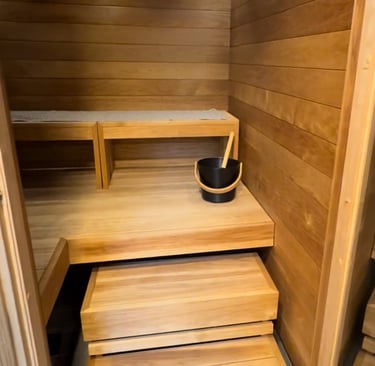 a wooden sauna with black water bucket