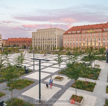 Architektoniczna fotografia Placu Nowy Targ we Wrocławiu o zachodzie słońca, ukazująca harmonijne po