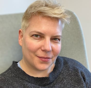 Portrait of a woman with short bleached hair and a blue sweater