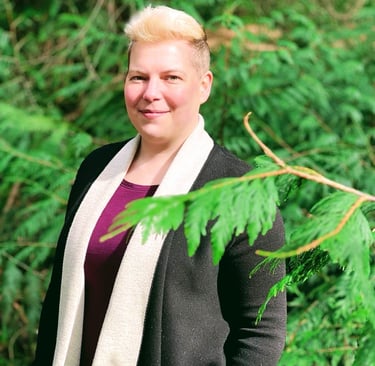 a woman in a black cardigan and jeans standing in front of a tree