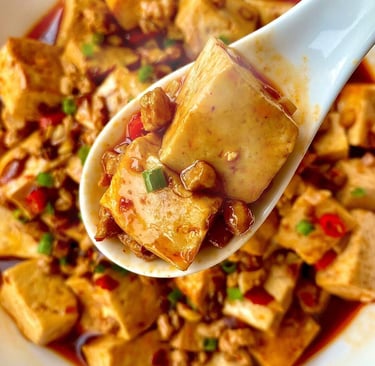 a spoonful of mapo Tofu with a spoon in it