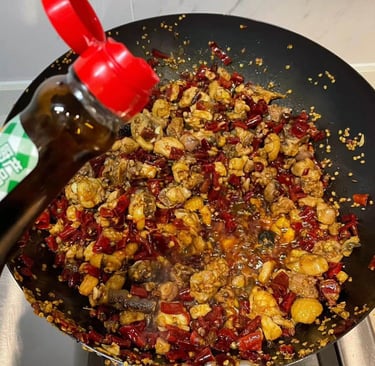 a pancaked with a bottle of soy sauce being poured into a pan